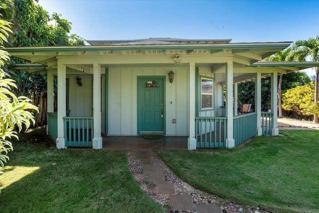 property entrance with covered porch, board and batten siding, and a yard