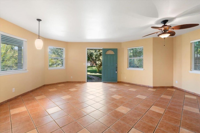 spare room featuring light tile patterned floors, baseboards, and a ceiling fan