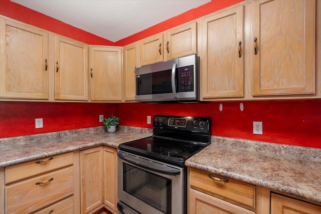 kitchen with appliances with stainless steel finishes, light brown cabinetry, and light countertops