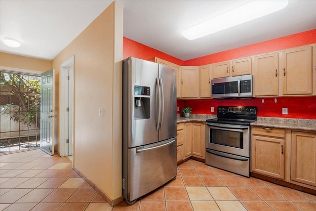 kitchen featuring light tile patterned floors, appliances with stainless steel finishes, and light brown cabinets