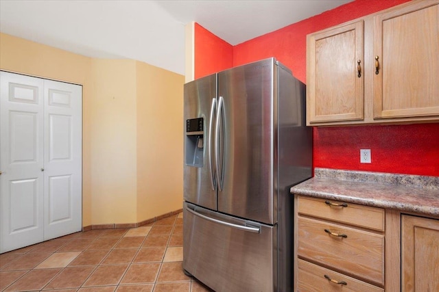 kitchen featuring light tile patterned floors, stainless steel fridge with ice dispenser, baseboards, and light brown cabinetry