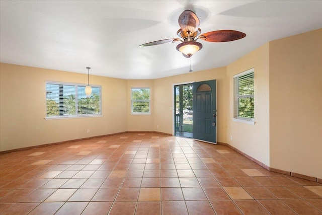 foyer featuring light tile patterned floors, baseboards, a wealth of natural light, and ceiling fan