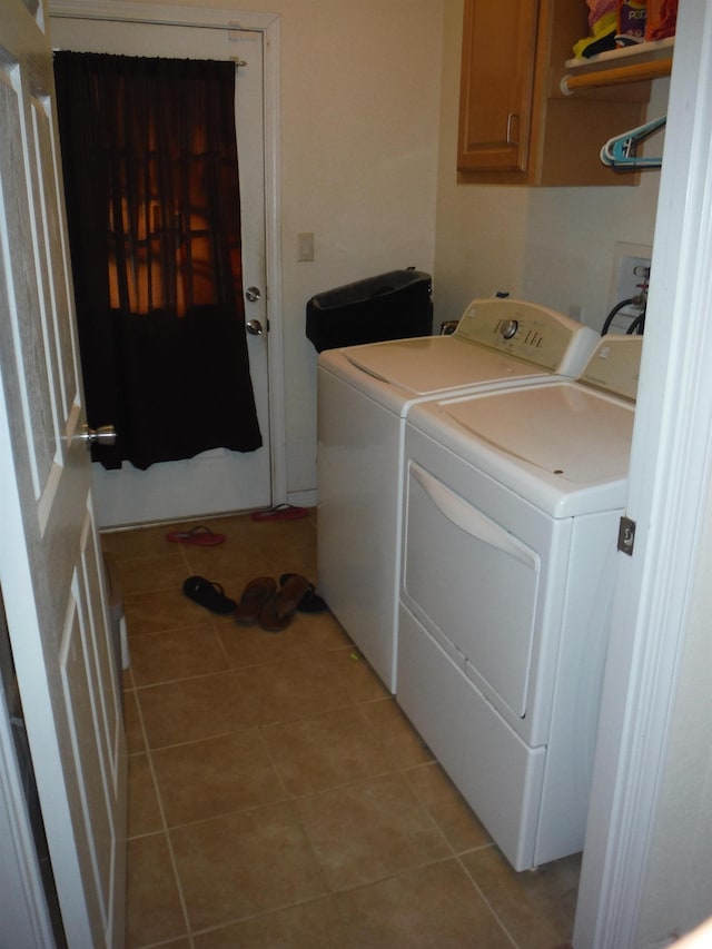 laundry room with cabinets, washer and dryer, and light tile patterned flooring