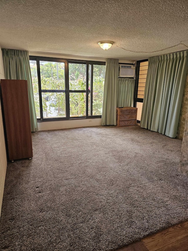 3785 Lower Honoapiilani Rd Unit 103, Lahaina, HI 96761 - carpeted spare room featuring a wall mounted AC and a textured ceiling