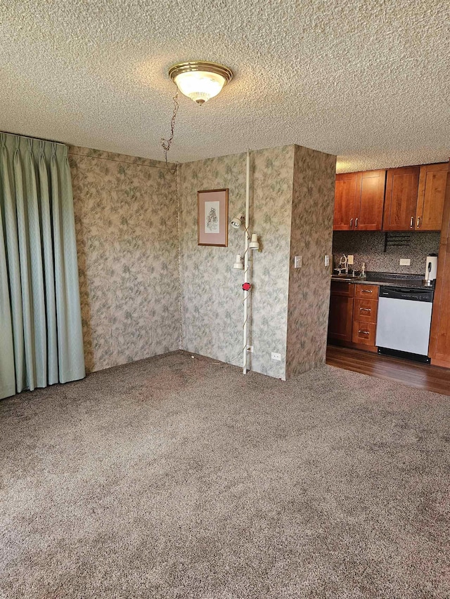 3785 Lower Honoapiilani Rd Unit 103, Lahaina, HI 96761 - kitchen featuring stainless steel dishwasher, carpet floors, a textured ceiling, brown cabinets, and dark countertops