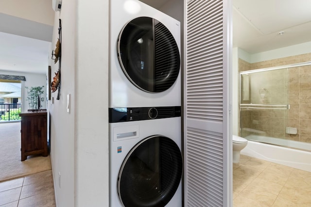 28 Hauwahine Ln Unit F203, Kihei, HI 96753 - laundry area featuring stacked washer / drying machine, tile patterned floors, and carpet floors