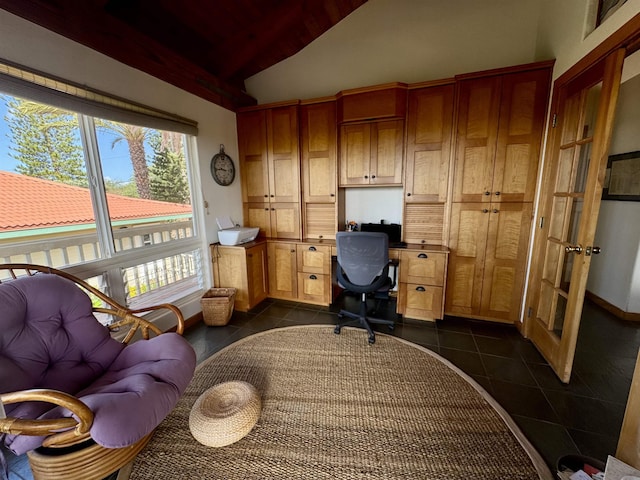 office with lofted ceiling, dark tile patterned floors, built in desk, baseboards, and wooden ceiling