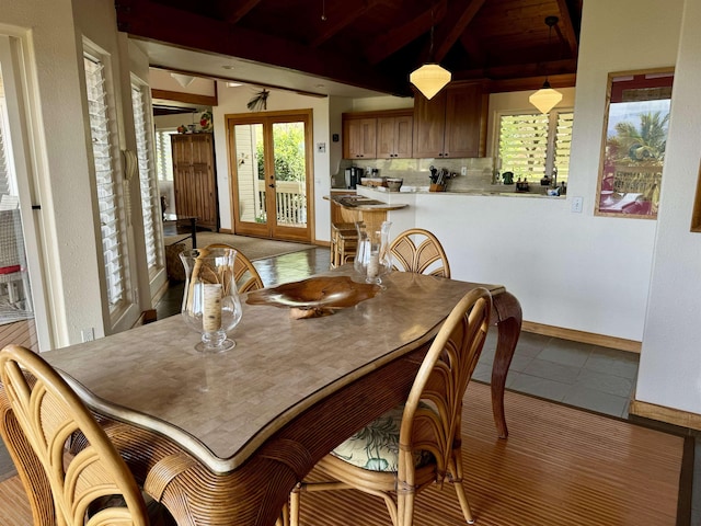 tiled dining room with baseboards and french doors
