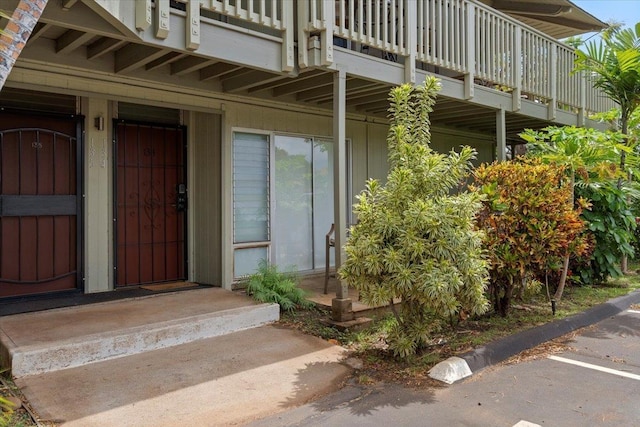 view of exterior entry with a balcony