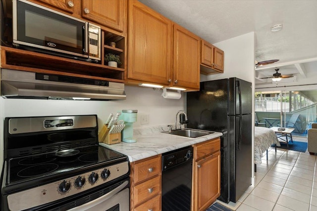 kitchen with black appliances, sink, ceiling fan, light tile patterned floors, and beam ceiling