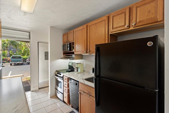 kitchen featuring a textured ceiling, light tile patterned floors, and black appliances