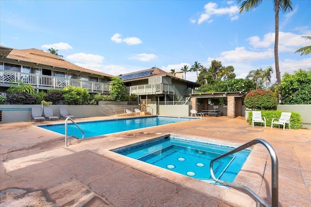 view of swimming pool featuring a hot tub and a patio