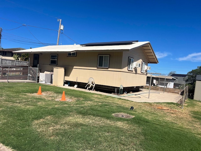 back of house featuring a lawn and a patio area