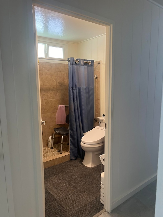 bathroom featuring toilet and curtained shower