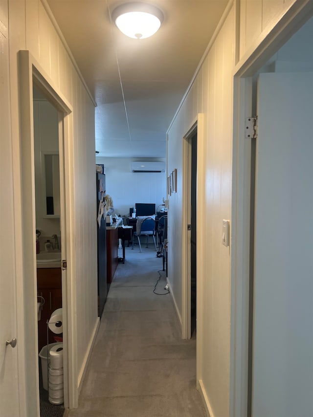 hallway with a wall unit AC, wooden walls, sink, and crown molding