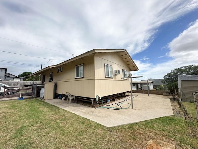 rear view of house featuring a storage unit, a patio, and a yard