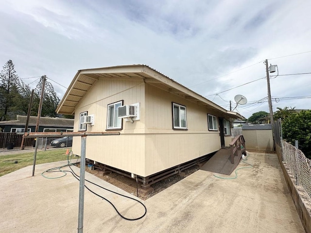 view of home's exterior featuring a patio and a wall mounted air conditioner