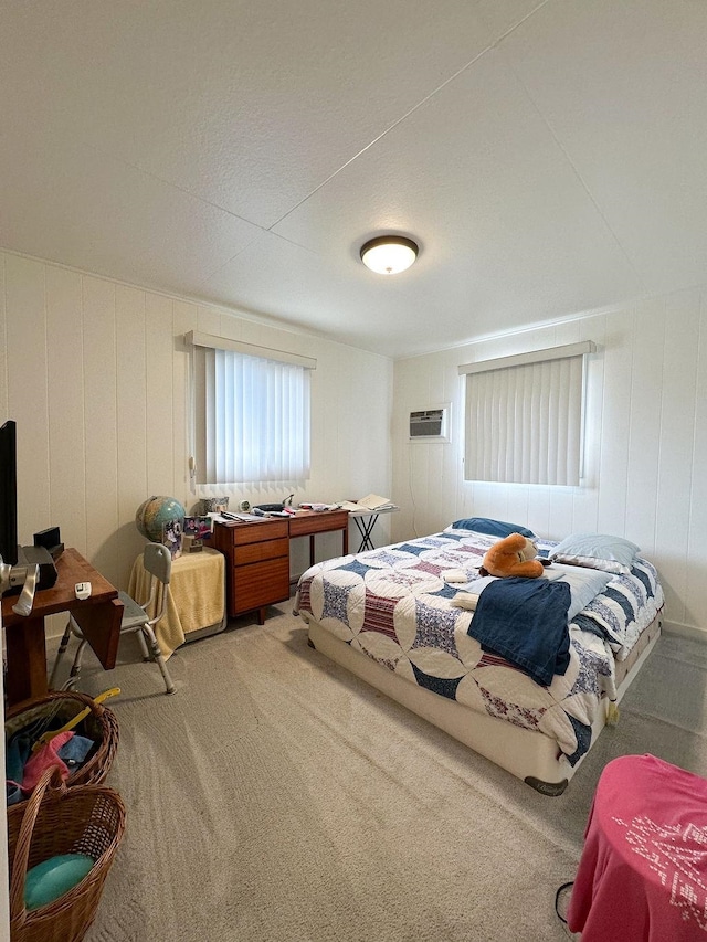 carpeted bedroom featuring wood walls and a wall mounted AC