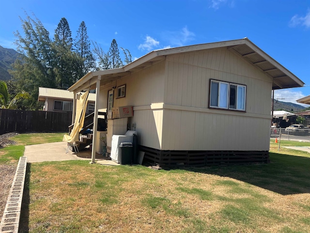 view of side of property featuring a patio and a yard