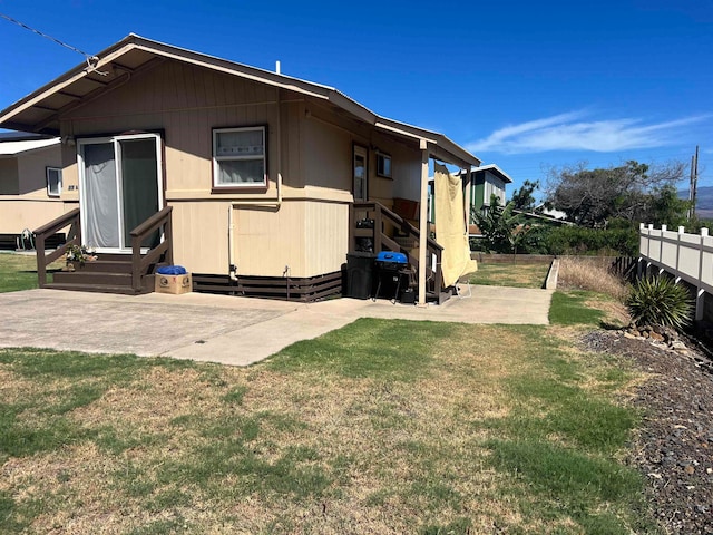 rear view of property with a patio and a yard