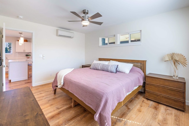 bedroom featuring light hardwood / wood-style flooring, an AC wall unit, and ceiling fan