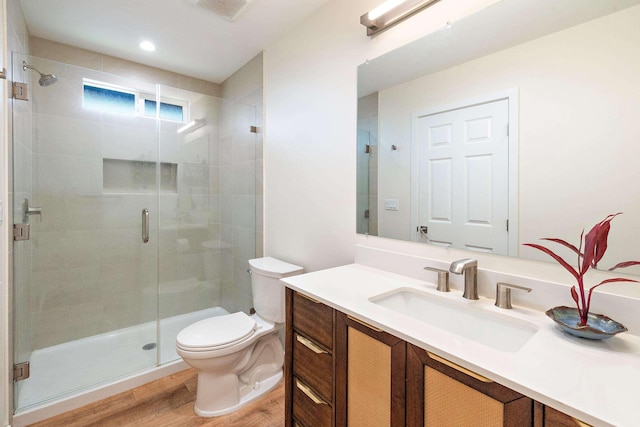 bathroom featuring hardwood / wood-style flooring, vanity, walk in shower, and toilet