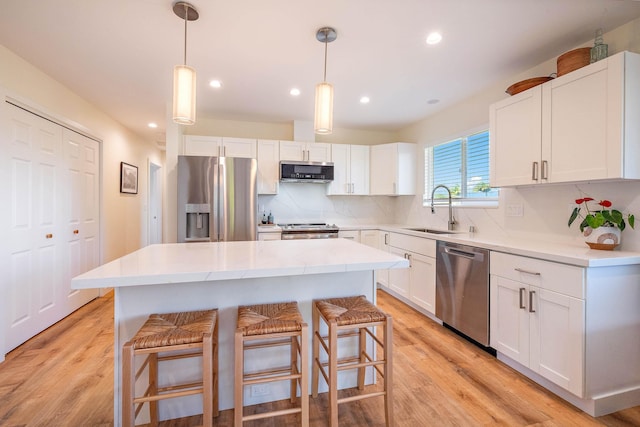 kitchen with stainless steel appliances, a center island, and white cabinets