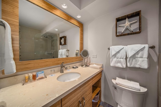 bathroom with toilet, a shower, and vanity