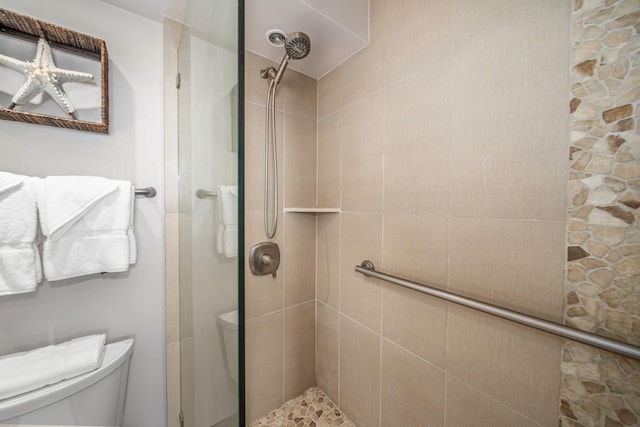 bathroom with toilet and a tile shower