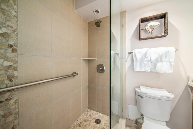 bathroom with toilet and a tile shower