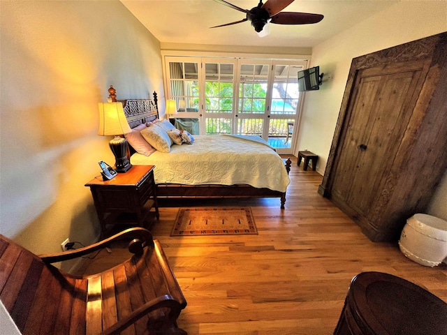 bedroom with ceiling fan, hardwood / wood-style floors, and access to outside