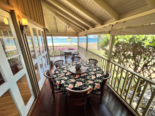 exterior space featuring an inviting chandelier, wooden ceiling, a view of the beach, vaulted ceiling with beams, and a water view