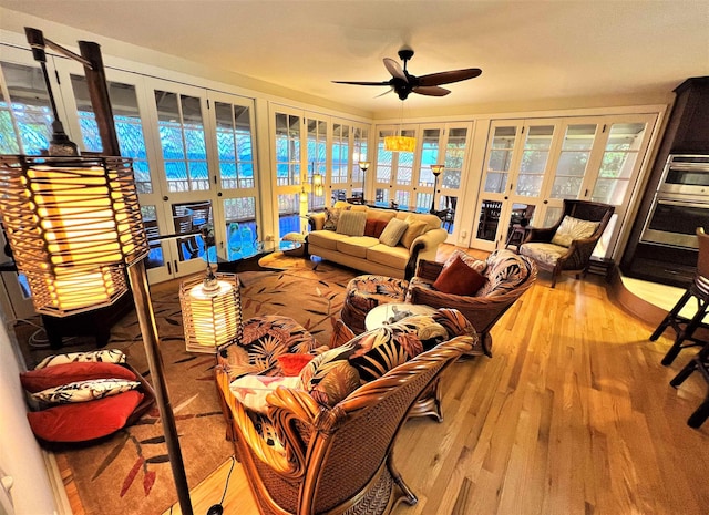 living room with light wood-type flooring, ceiling fan, and french doors