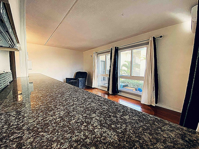 unfurnished bedroom featuring dark hardwood / wood-style flooring and a textured ceiling