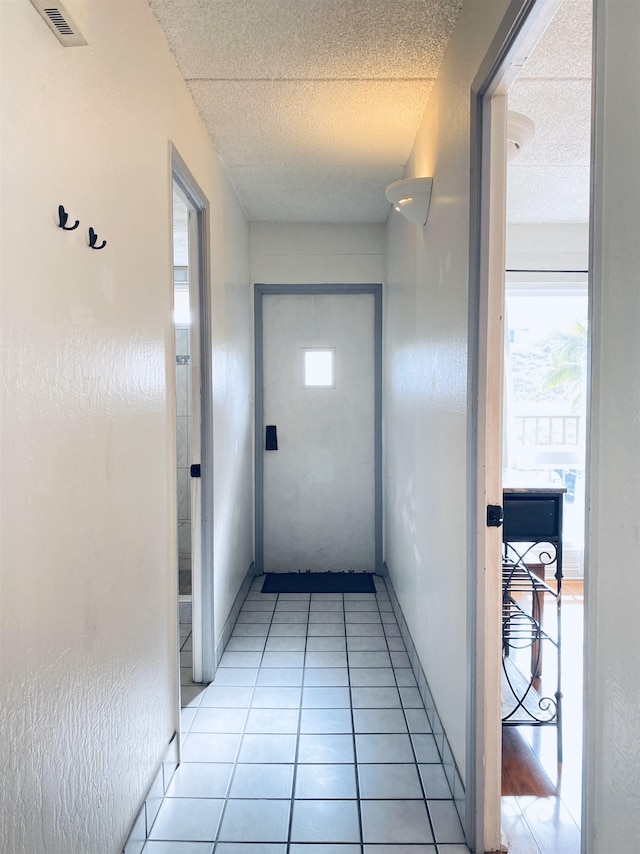 corridor with plenty of natural light and light tile patterned flooring