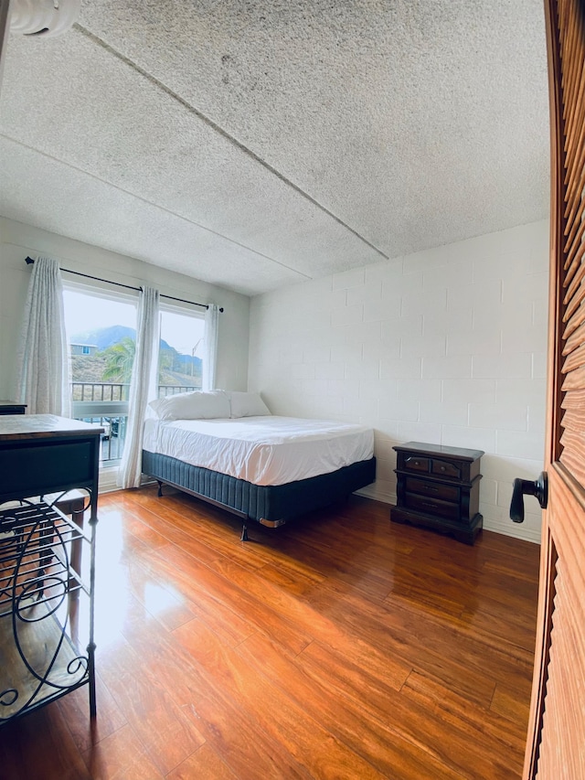 bedroom featuring wood-type flooring and a textured ceiling