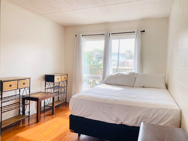 bedroom featuring a textured ceiling and hardwood / wood-style flooring