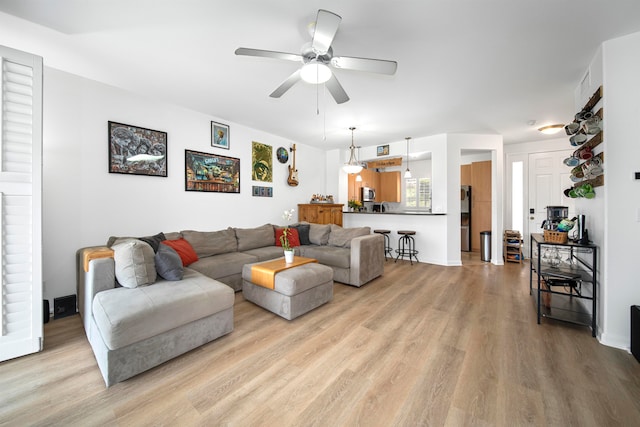 living room featuring light hardwood / wood-style floors and ceiling fan