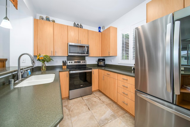 kitchen featuring light tile patterned flooring, appliances with stainless steel finishes, sink, and decorative light fixtures