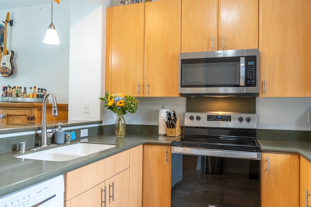 kitchen featuring appliances with stainless steel finishes, sink, hanging light fixtures, and tile patterned flooring