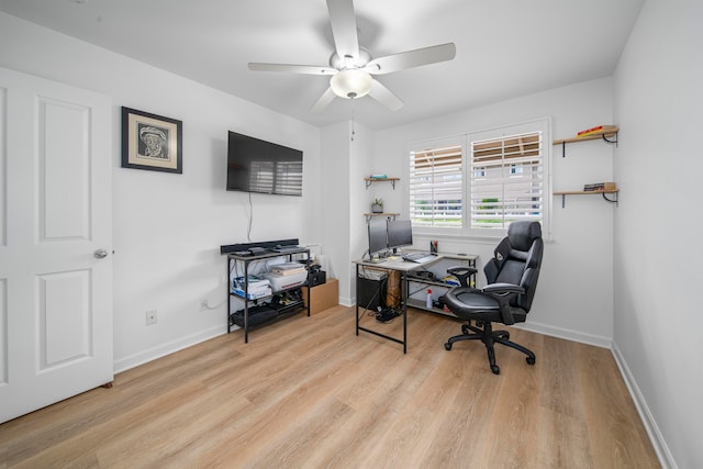 home office with light hardwood / wood-style flooring and ceiling fan