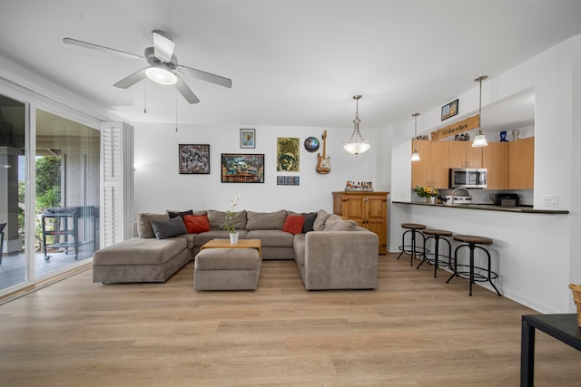 living room with light wood-type flooring and ceiling fan