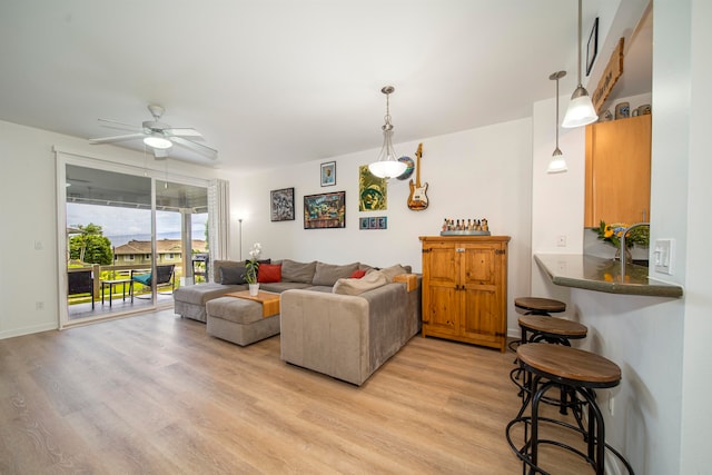 living room with ceiling fan and light hardwood / wood-style flooring