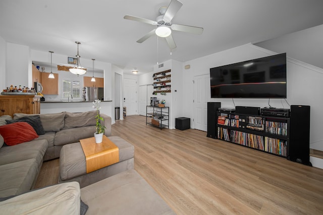 living room with ceiling fan and light hardwood / wood-style flooring