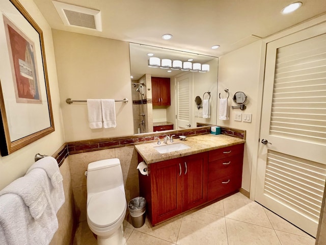 bathroom with a shower with door, tile patterned flooring, tile walls, toilet, and vanity