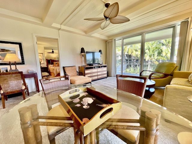 carpeted dining space featuring ceiling fan and beam ceiling