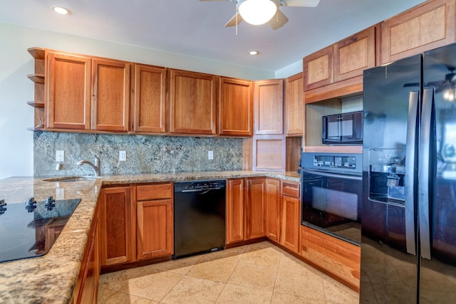 kitchen featuring black appliances, light stone counters, sink, and tasteful backsplash