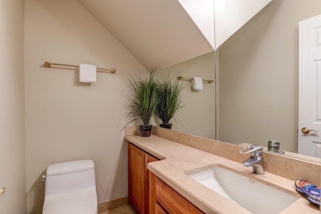 bathroom featuring vanity, toilet, and lofted ceiling