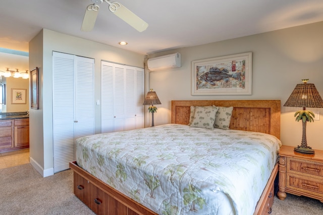 carpeted bedroom featuring two closets, ceiling fan, and a wall mounted air conditioner