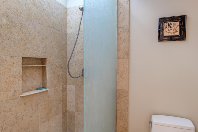 bathroom with tiled shower and toilet